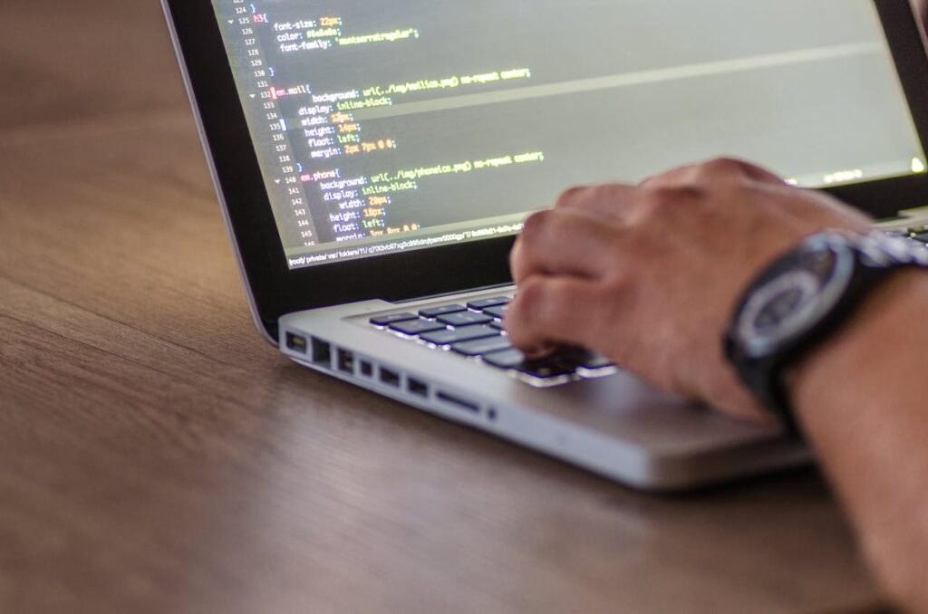 pexels-photo-574071 A close-up shot of a person coding on a laptop, focusing on the hands and screen.